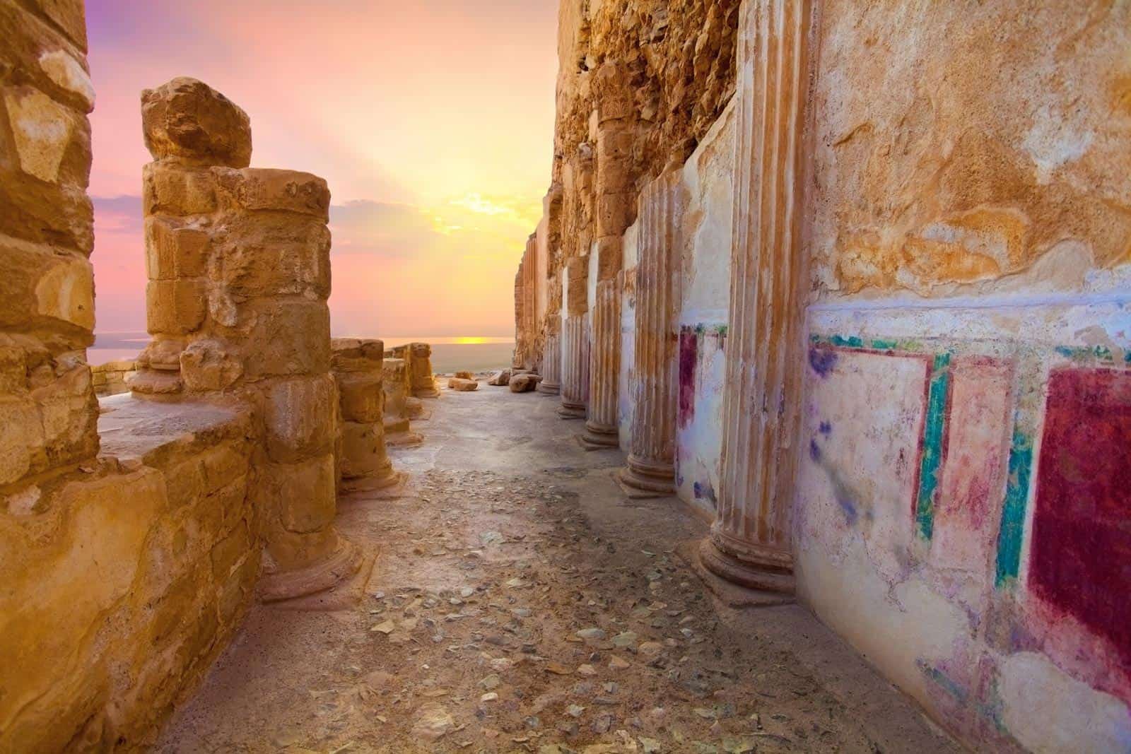 The ruins of King Herods Palace at Masada with a beautiful sunset in the background.